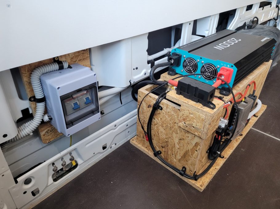 Batteriesystem mit Steuerungseinheit, montiert auf einer Holzplatte.